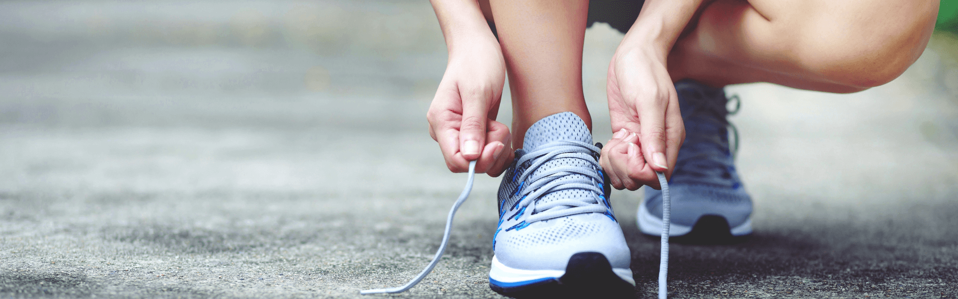 A young woman ties up her shoes before her morning run